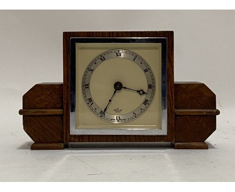An Elliot Art Deco oak time piece mantel clock, early 20th century, the cream dial with silvered and black painted Roman nume