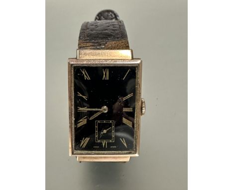 A gents 9ct gold cased 1930s Tank shaped wristwatch with black enamel dial and gilt roman numerals and subsidiaries dial comp