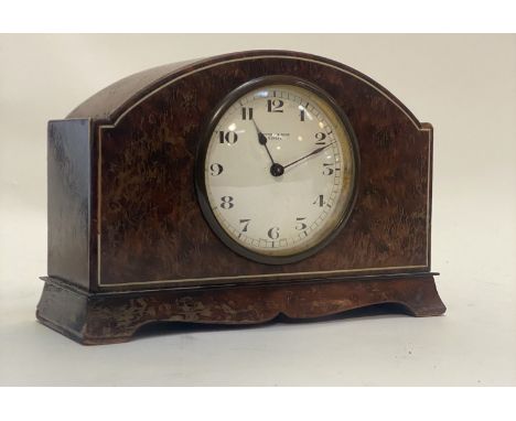 A 1930's mantel clock, the domed yew wood case with ivorine string inlay enclosing a white enamel with Arabic chapter ring in