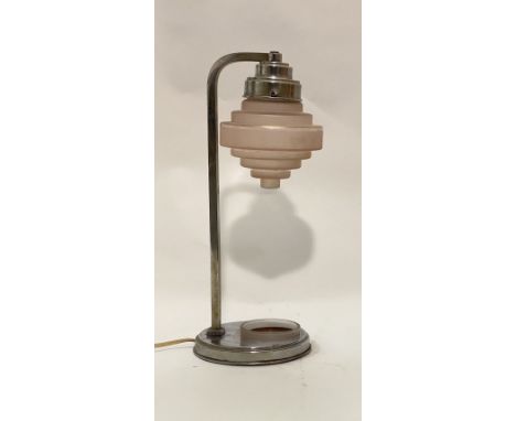 An Art Deco period table lamp of characteristic form, the pink stepped cylindrical glass shade on a chromed metal stand with 