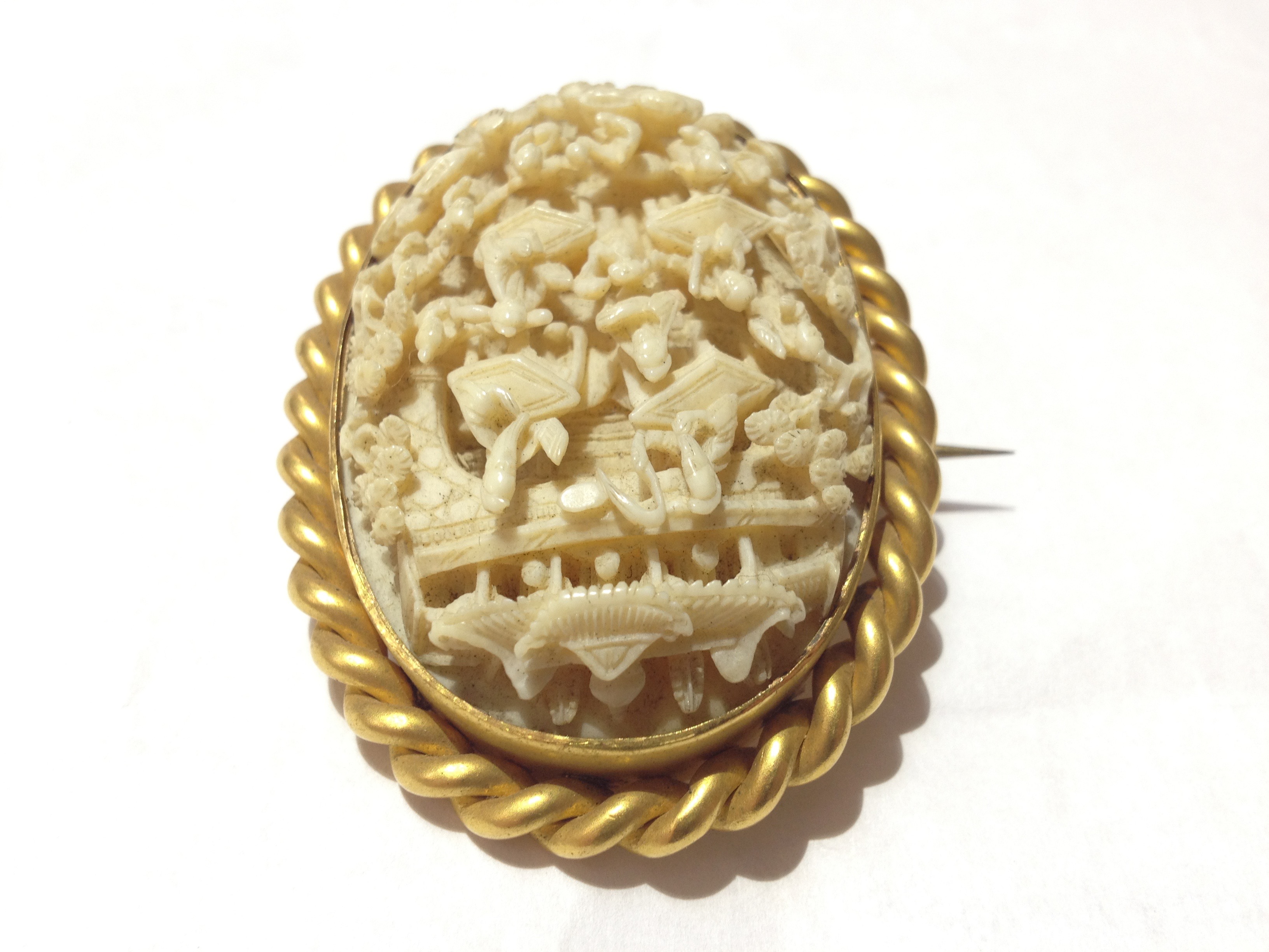 A 19th Century Chinese Canton carved ivory brooch set in twist yellow