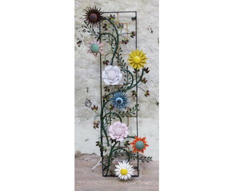 A retro wall mounting light fitting formed as clinging plants with flowers on a metal trellis, height 144cm.