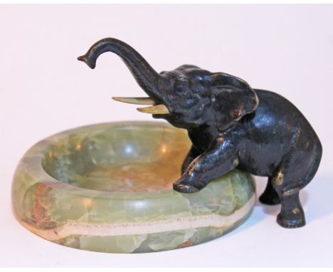 An Art Deco green onyx ashtray mounted with patinated bronze elephant with ivory tusks circa 1930s, the base inscribed 'Austr