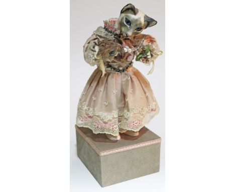 A Swiss automaton by Reuge circa 1960s, formed as a cat holding flowers and wearing a pink and lace dress, height 42cm. Condi