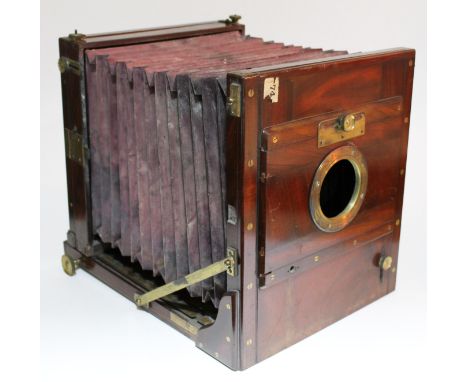 A large 19th Century mahogany and brass mounted plate camera with leather case.
