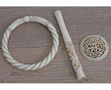 Three pieces of Chinese carved ivory circa 1900 comprising a cheroot holder, a bangle and a pierced roundel.