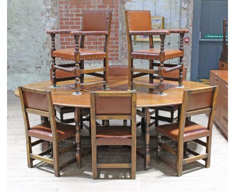 An 18th Century style oak wake table with turned supports and double gate leg action with eight studded leather chairs, lengt