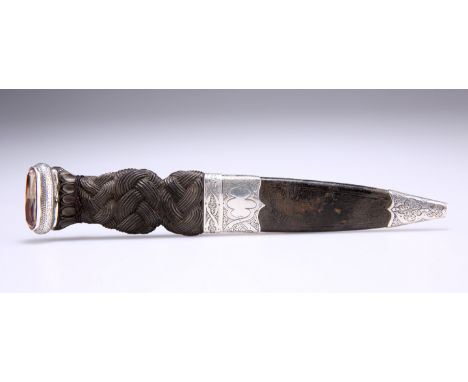 A SCOTTISH SILVER-MOUNTED SGIAN DUBH, unmarked, carved ebony grip, the pommel set with foil-backed glass stone. 19.1cm long o