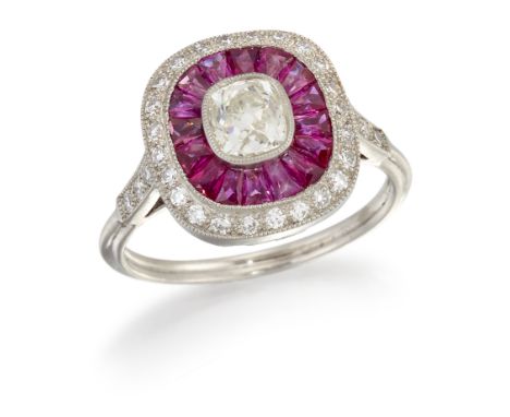 A RUBY AND DIAMOND CLUSTER RING, an old-cut diamond in a milgrain setting within an oval border of calibre-cut rubies and an 