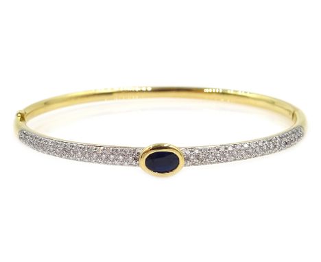 18ct gold hinged bangle, with a central rim set oval sapphire and pave set diamonds either side, stamped 750, sapphire 0.65 c