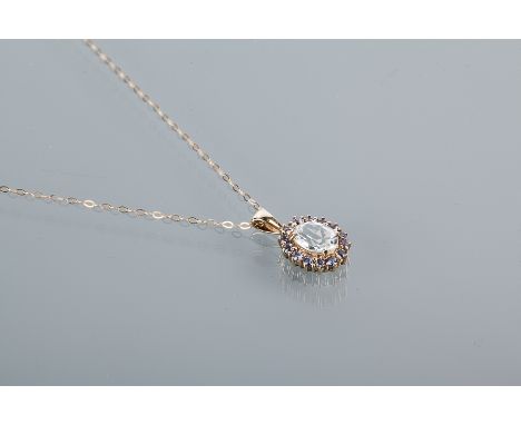 LARGE QUARTZ AND TANZANITE PENDANT
with a large oval shaped quartz 9.11mm long, surrounded by brilliant cut tanzanites, in ni