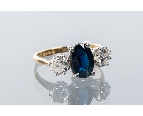 SAPPHIRE AND DIAMOND THREE STONE EIGHTEEN CARAT GOLD RING
with a central oval sapphire measuring 9mm x 6mm flanked by two bri