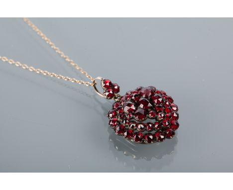 EARLY TWENTIETH CENTURY GARNET PENDANT
formed with a cluster of graduated garnets in an unmarked white metal setting, on an u