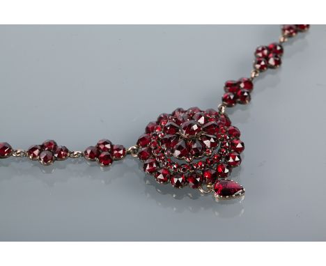 VICTORIAN GARNET SET NECKLACE
with a central principal garnet cluster 25mm diameter, the chain formed by clusters of round ga