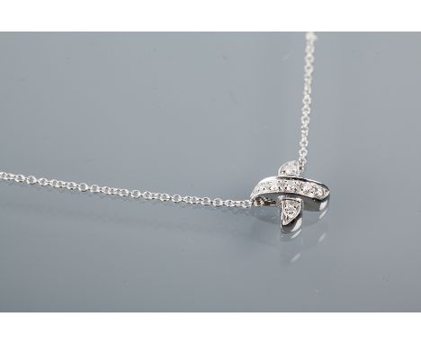 TIFFANY & CO DIAMOND SET PENDANT
in the form of a cross, set with brilliant cut diamonds, in eighteen carat white gold, on an