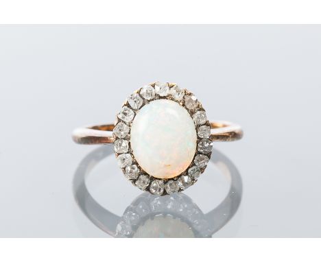 OPAL AND DIAMOND CLUSTER RING
with a central oval cabochon cut opal, surrounded by old cut diamonds, marked 18ct, size N