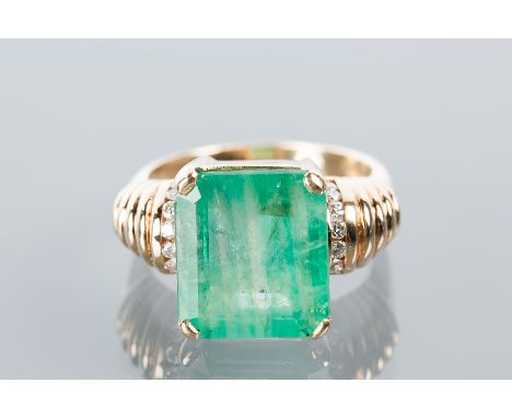 EMERALD AND DIAMOND RING
the large emerald cut emerald measuring 13.8 x 12.09mm, the shoulders of ribbed design, channel set 