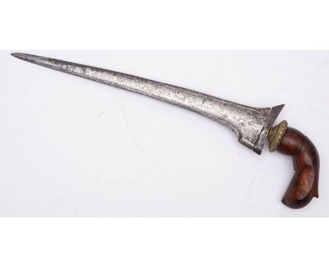 An Indonesian kris, the straight double edged Damascus blade over a gilt brass circular floral cast hilt and carved one piece
