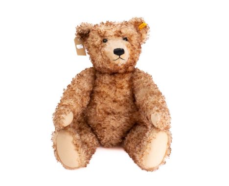 A Steiff mottled plush Teddy bear,  plastic eyes, stitched nose and mouth, button and label to ear over a jointed body with g