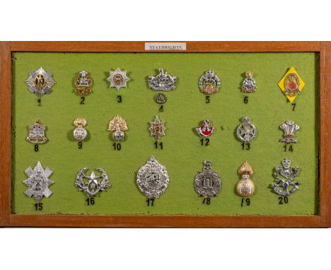 A framed group of  twenty British Army Staybright cap badges,  including The Queen's Regiment, Yorkshire and others.  