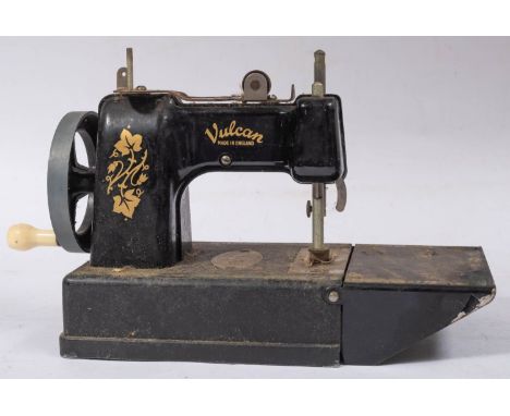 A Vulcan Tinplate toy sewing machine with remains of original box and a small trunk case. 