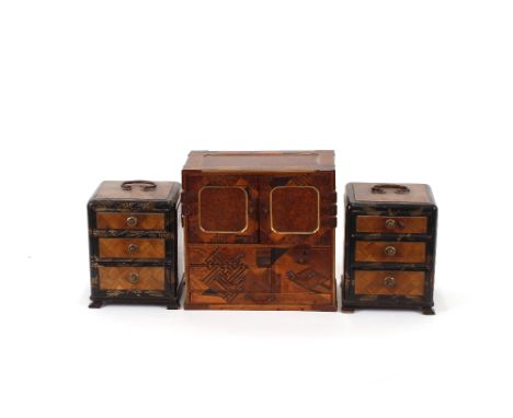 A Japanese parquetry decorated trinket box, 22cm wide x 21cm high; and a pair of Japanese lacquered three drawer trinket ches