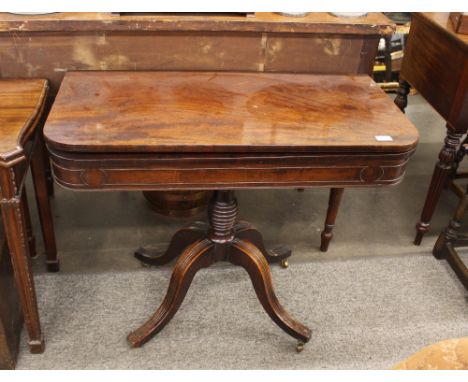 A Regency mahogany card table, the foldover swivel top raised on ring turned baluster column with quadruple splay, terminatin