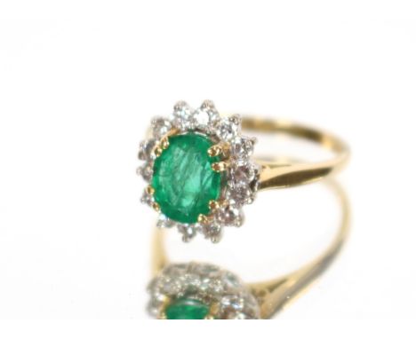 An 18 carat gold emerald and diamond set cluster ring