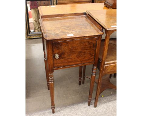 A Victorian mahogany tray top bedside cupboard, enclosed by a single door, raised on ring turned tapering supports, 38cm wide