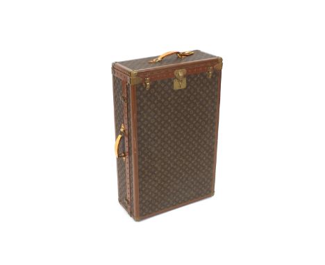 A 20th Century Louis Vuitton wardrobe trunk, with monogrammed decoration, brass caps and studded bands, the monogrammed brass