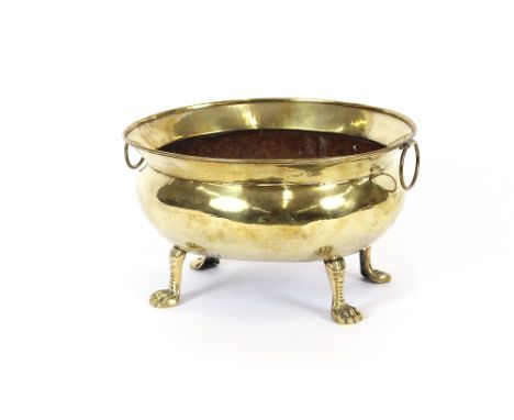 A 19th Century brass wine cooler, of elliptical form, flanked by ring handles, baluster body on splayed legs and paw feet, 35