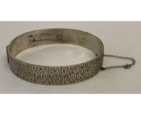 A vintage silver hinged bangle with brushed design detail, complete with safety chain.  Hallmarked Birmingham 1970.  Total we