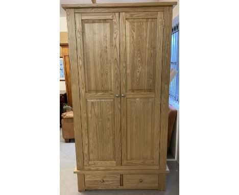 A modern light oak, solid wood double wardrobe with two drawers and internal hanging rail.   Approx. 200 x 107 x 64cm.