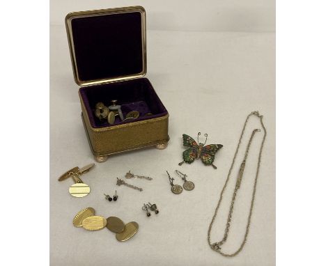 A small gold tone velvet lined trinket box containing jewellery, cufflinks and shirt studs.  Jewellery includes a silver rope