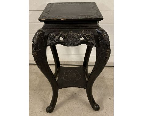 A vintage oriental design, ebonised carved wood jardinière with shaped legs and scroll feet.  Floral carved decoration to top