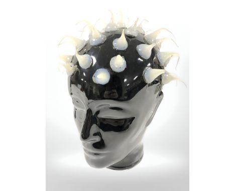 A hollow slip cast black ceramic head of a lady with applied 'hair', height 25 cm.