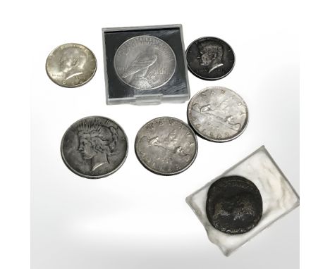 Two American liberty dollars, 1922 and 1927, two U.S. half dollars, two Canadian dollars, and a further ancient Roman coin.