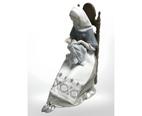 A Lladro figure of a seated lady doing embroidery, height 28 cm.