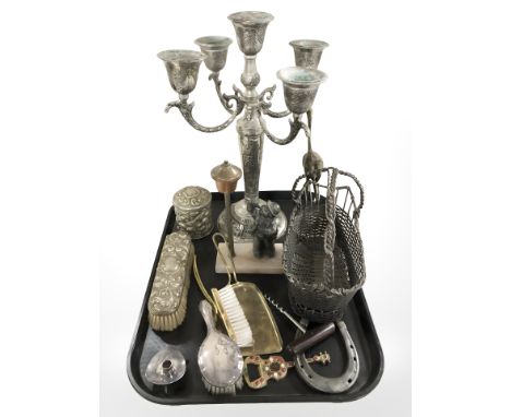 An ornate EPNS candelabrum, basket, vintage corkscrew, dressing table brushes, Art Deco table lighter surmounted by a man, et