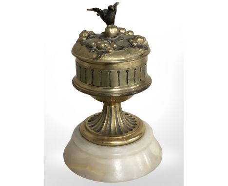 An onyx and gilt metal mounted ink well with ceramic liner surmounted by a bird, height 11 cm.
