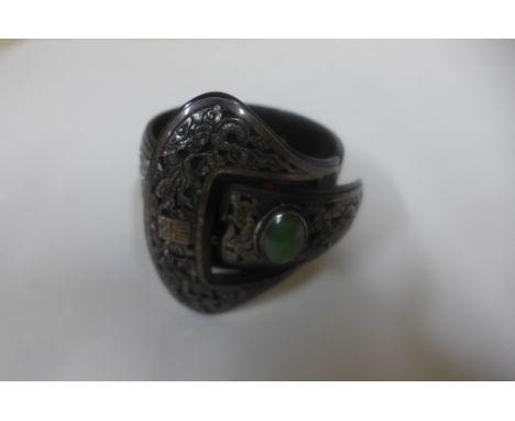 A Chinese folding tortoiseshell and white metal folding bangle set with a green jade cabouchon, 7cm wide when closed, general