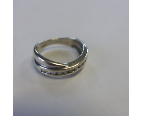 A 9ct hallmarked white gold diamond crossover band ring, 0.25ct, size L/M, approx 3.2 grams, some usage marks but generally g