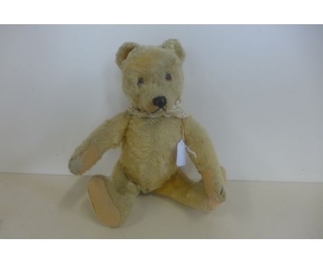 A 1950's bear, probably Steiff, 30cm tall, no button, golden mohair with some wear, old repairs to felt pads 