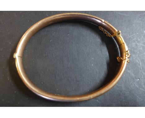 A 9ct rose gold hinged bangle, fully hallmarked, hollow, not filled, weight approx 7.8 grams - many dents 