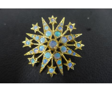 A good quality 18ct gold and opal star brooch, set with 33 cabachon polished opals, not hallmarked but tested as 18ct, brooch