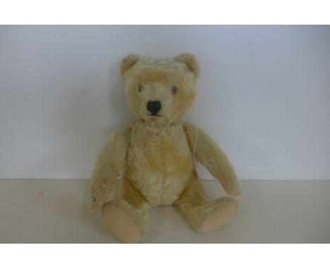 A Steiff bear circa 1950/60's, 28cm tall, button in ear, Golden mohair and felt pads, in good condition, small mark under mou