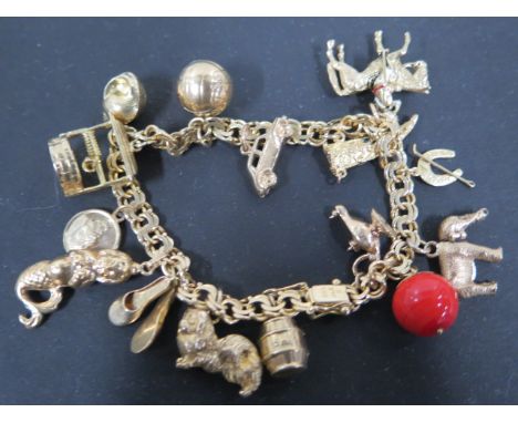 A 14ct gold charm bracelet with fifteen charms, mainly 9ct, total weight approx 49.6 grams, clean condition, some wear to cha