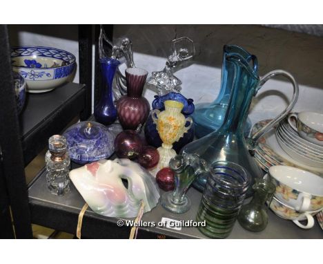 Decorative glassware including two dancer figurines, pair of tall red glass candle holders, blue glass jugs; a ceramic face m