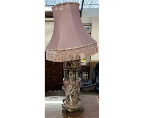 A pottery oil lamp converted to a table lamp on a brass base 