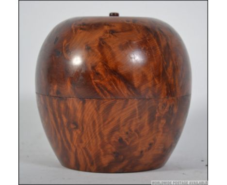 A Georgian style olive wood tea caddy in the form of an apple. The apple opening from the centre. Measures: 12cms wide.
